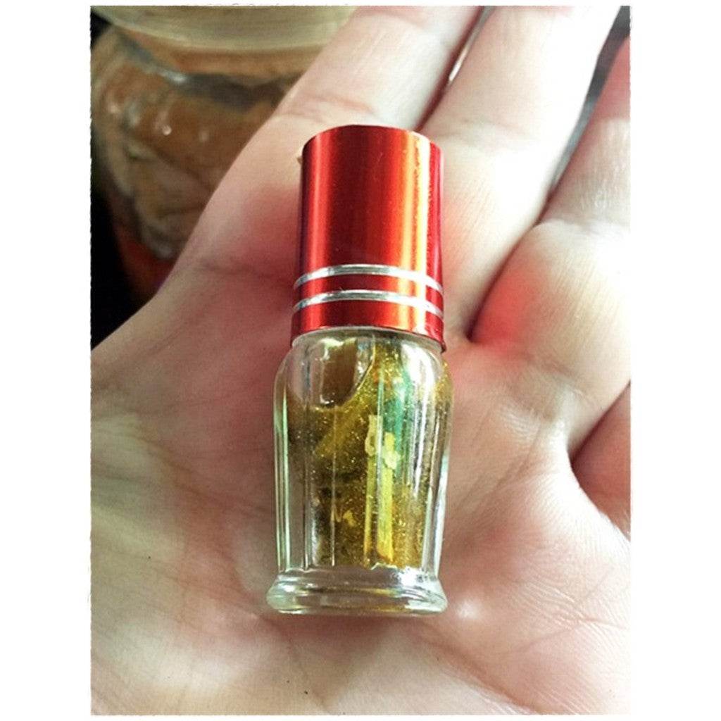 Maha Phokasap oil for luck and wealth in a small glass bottle held in hand
