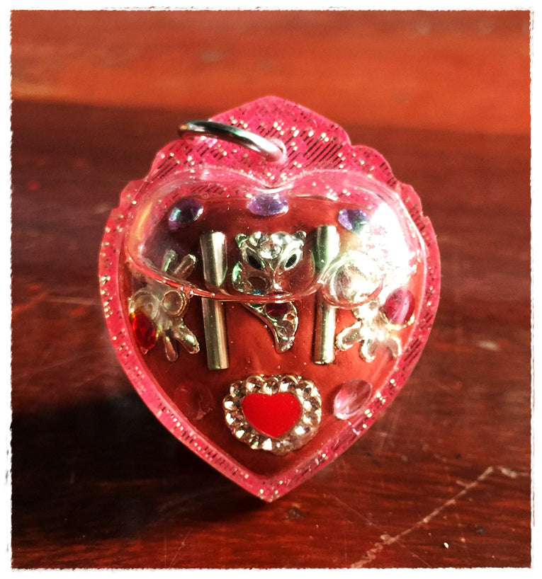 Thai amulet for love and fortune heart shaped red amulet in clear pink heart case with silver floral charms and hanging ring