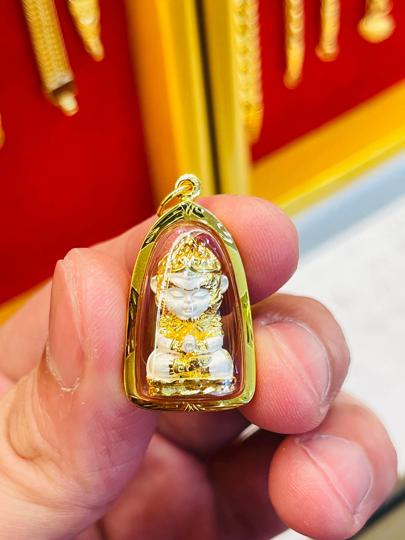 Monkey King fortune amulet in gold casing held by hand for good luck and protection