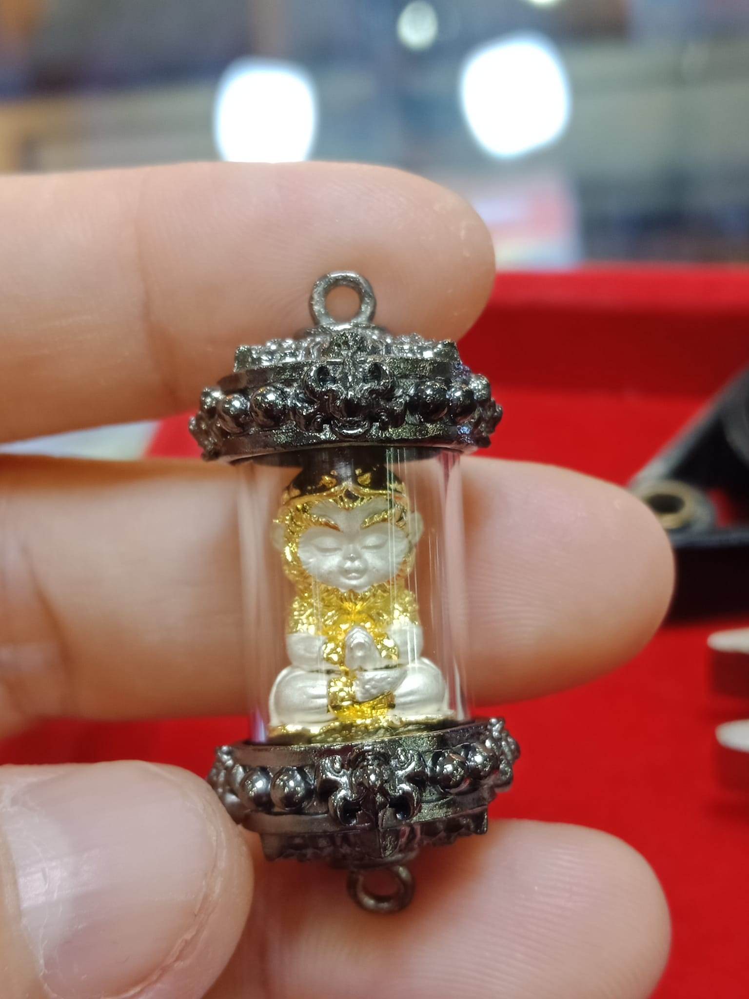 Handcrafted Monkey King fortune amulet in a glass casing, detailed gold accents and vibrant colors
