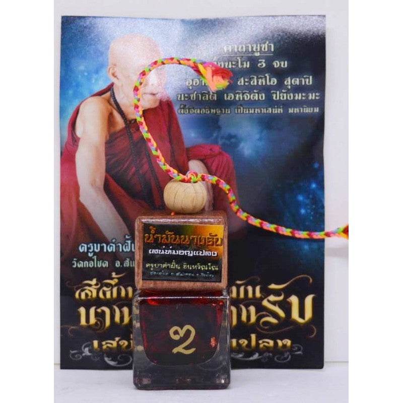 Namman Nang Rab spiritual oil bottle with colorful cord and accompanying spiritual guide