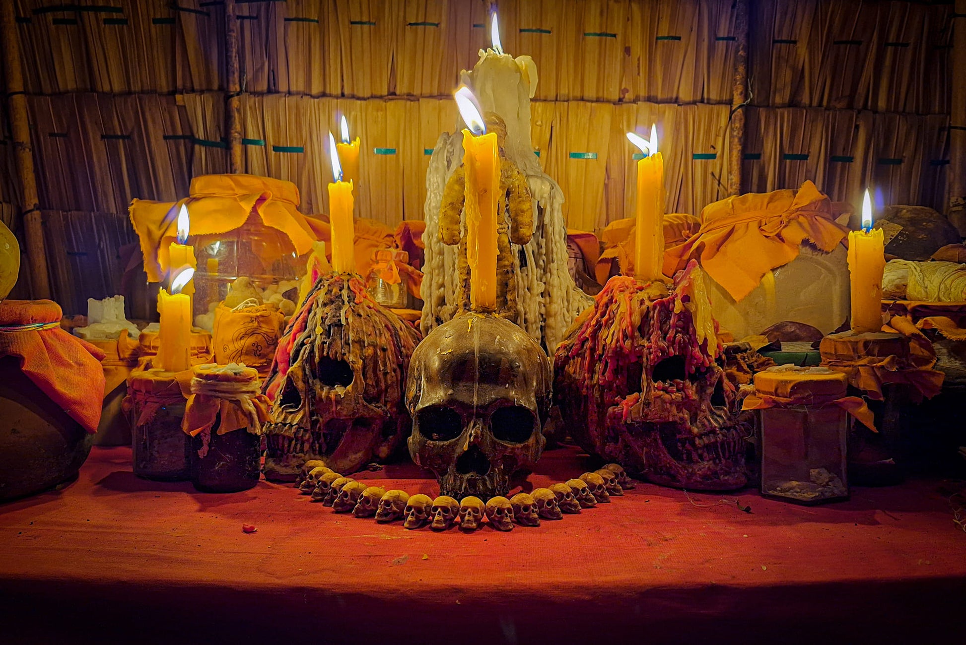 Namman Prai balm for spiritual power on Thai altar with skulls candles jars and offerings