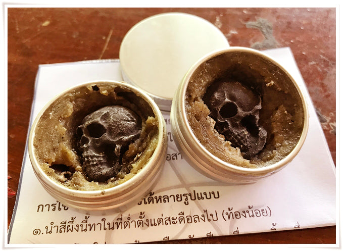 Thai Blessing Co Namman Prai balm for spiritual power two open tins with dark skull shaped balm