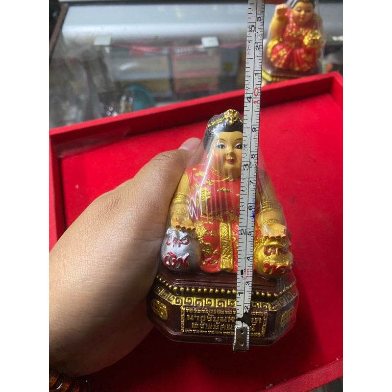 Nang Rap Maha Lap Sap Sombun statue for prosperity held in hand with measuring tape for size reference.
