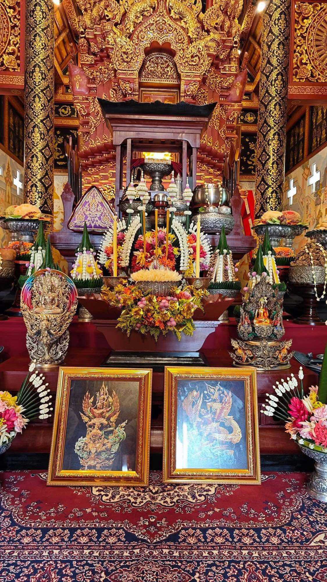 Decorative shrine displaying Narayana on Garuda amulet along with intricate floral arrangements and religious artifacts