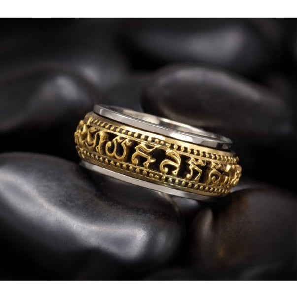 Close up of Thai Buddhist amulet jewelry gold and silver ring with engraved script on black stones