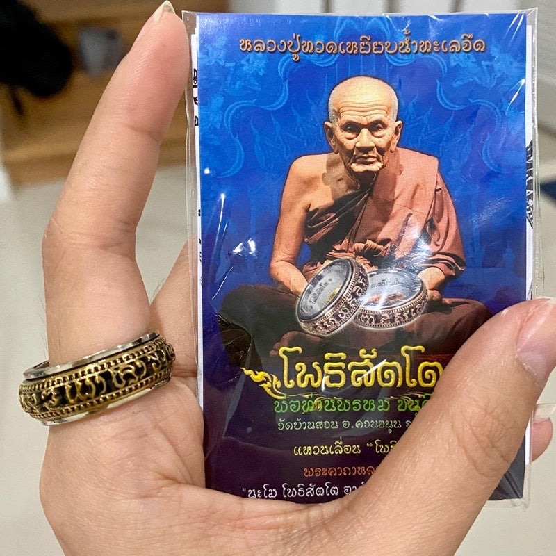 Thai Buddhist amulet jewelry ring held by hand with monk card from Thai Blessing Co