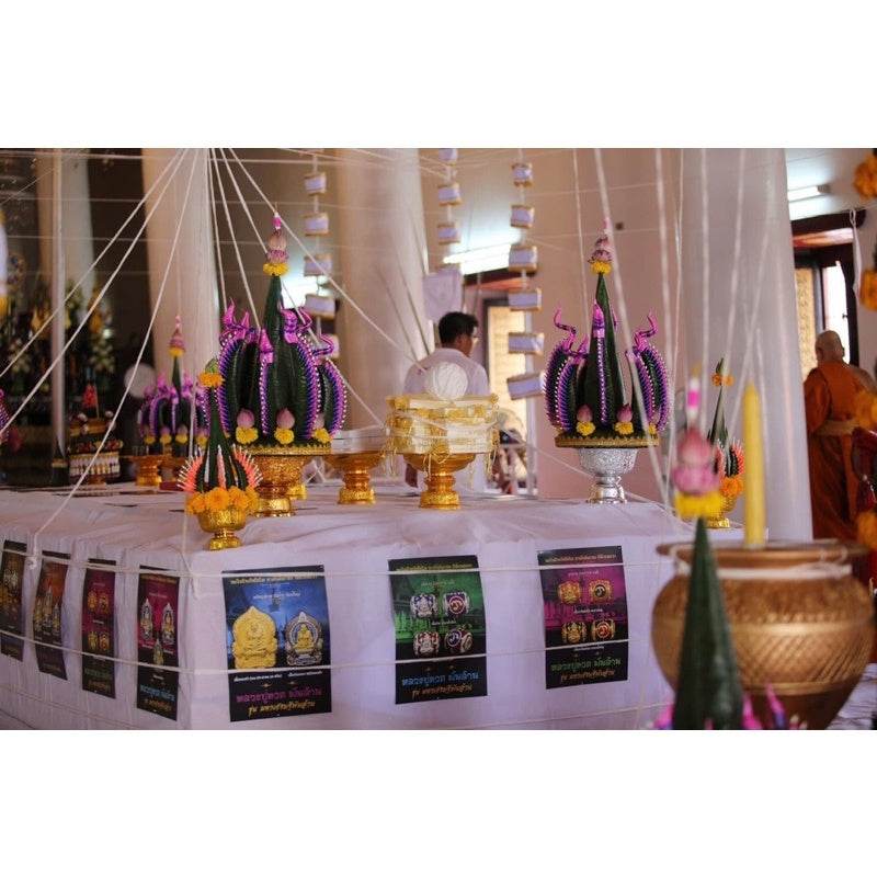 Billionaire Prosperity Thai amulet ceremonial display with gold bowls and pink lotus floral offerings on temple table