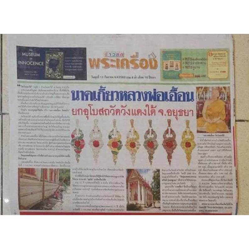 Thai newspaper article showing multiple ornate Naga wealth elevation amulet designs displayed in a row