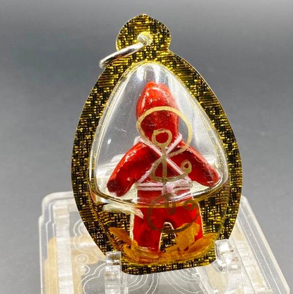 Thai Blessing Co oil-wrapped spirit doll for protection in red with gold details in clear amulet casing