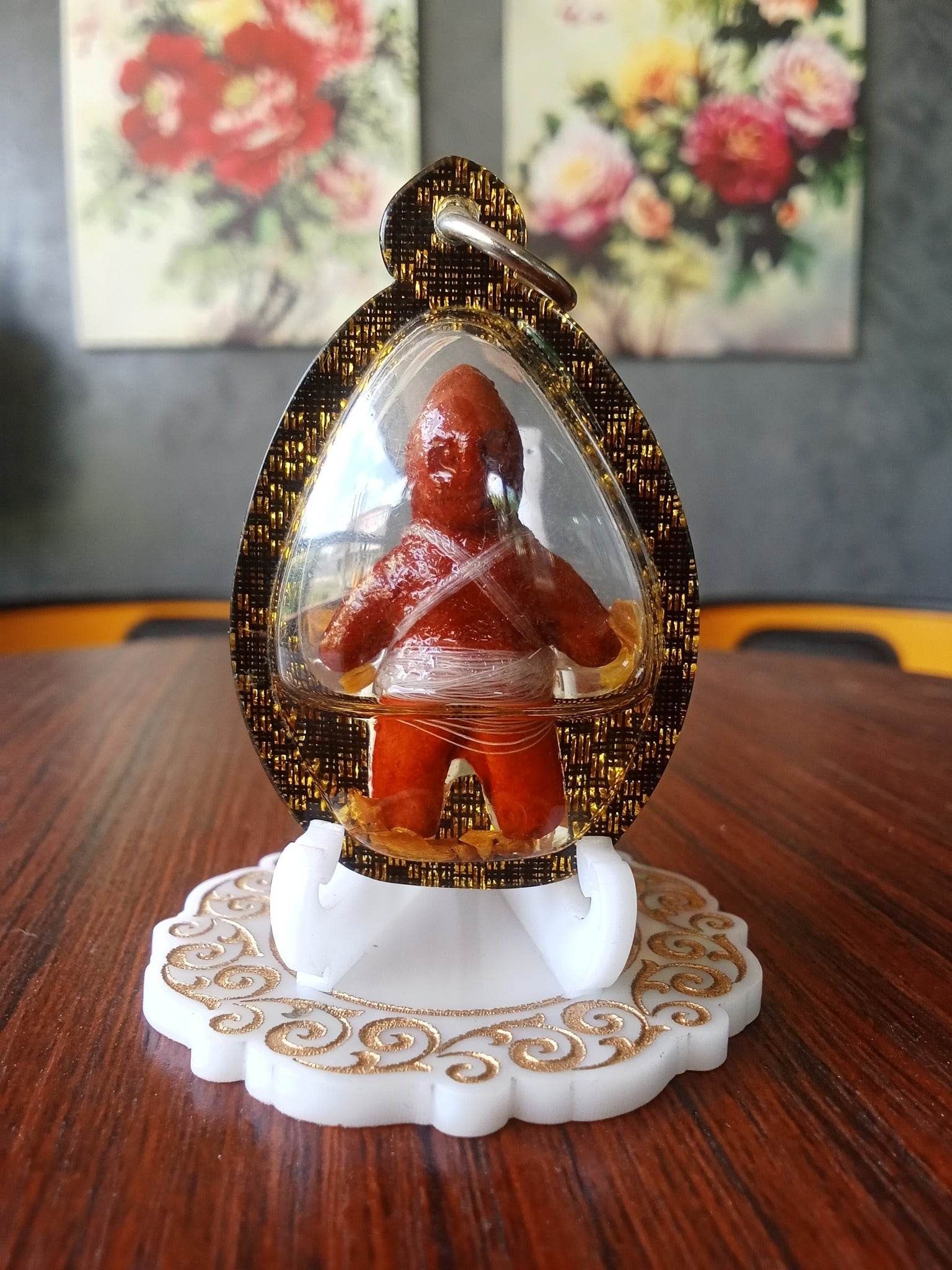 Oil-wrapped spirit doll for protection encased in clear protective cover on decorative stand