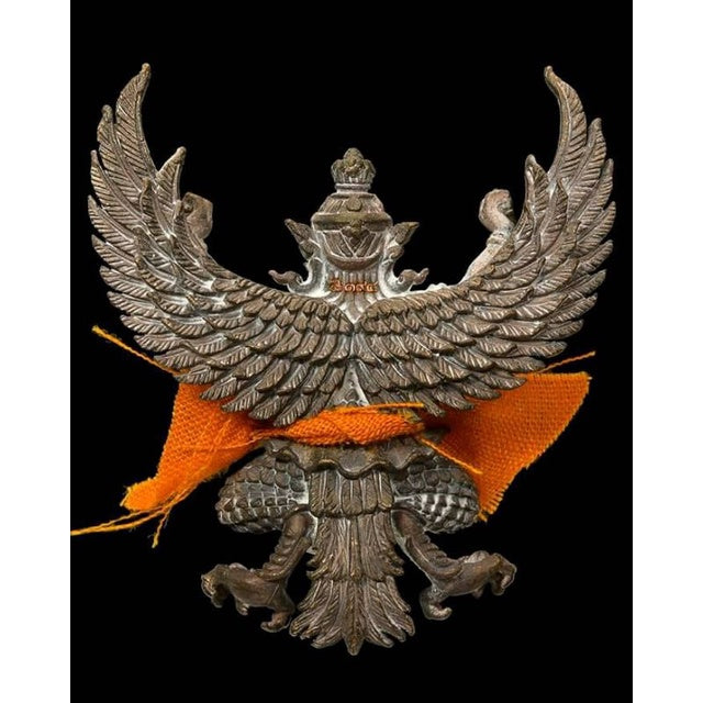 Phaya Garuda amulet for sale by Thai Blessing Co with detailed metal wings and orange cloth