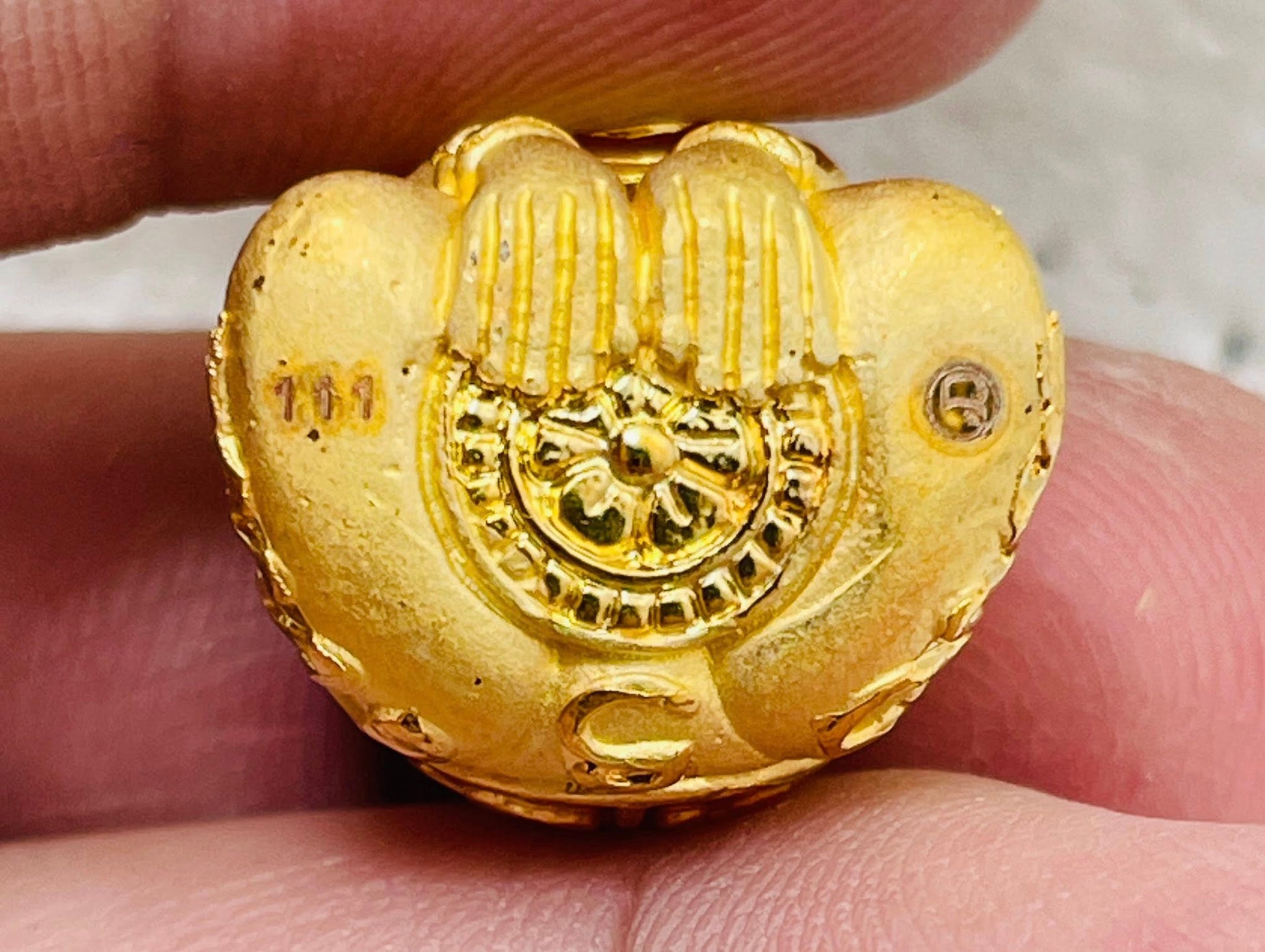 Close-up of Phaya Kob Kin Duean charm in gold color featuring detailed design and engravings