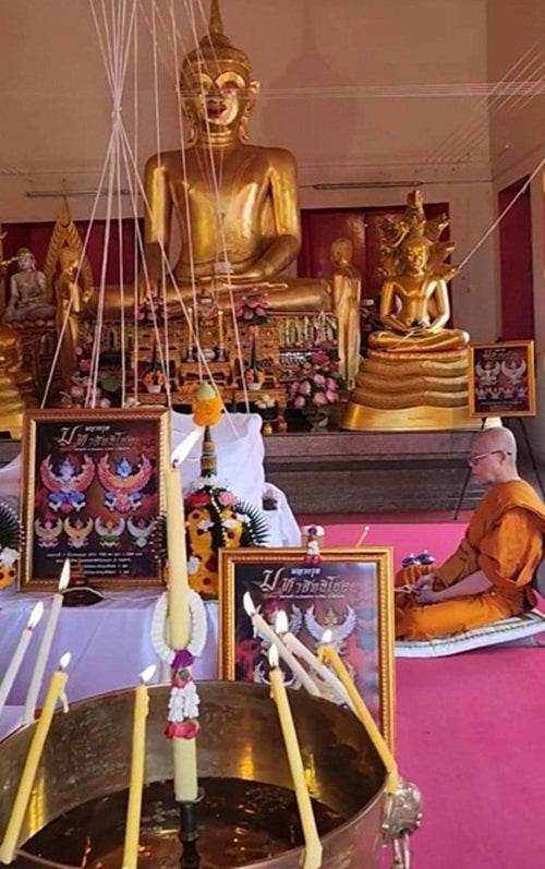 Phaya Krut amulet for protection displayed in a serene temple setting with decorative offerings and monk meditating