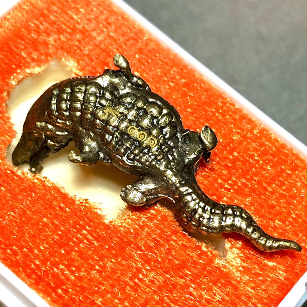 Phaya Kumphee Crocodile amulet in detailed design on bright orange background for good fortune and protection