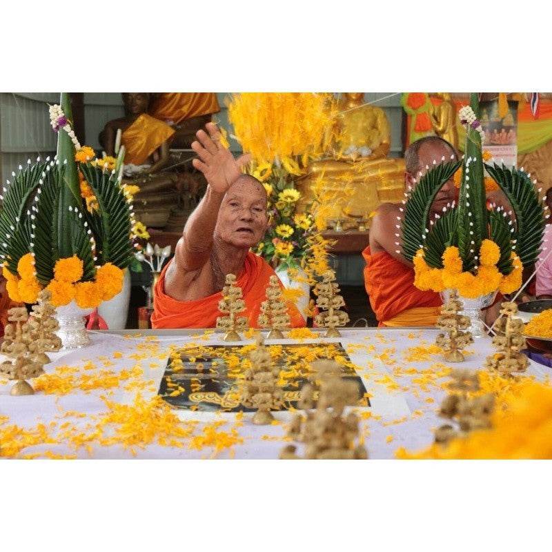 Monk performing a blessing ceremony with offerings for the Phaya Moo Setthi sacred pig figurine