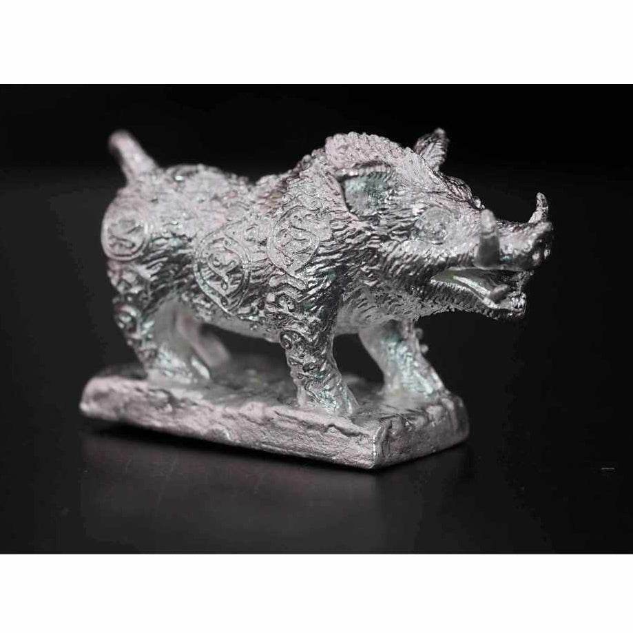 Silver Phaya Waraha wealth charm in the shape of a boar with detailed engravings on a rectangular base