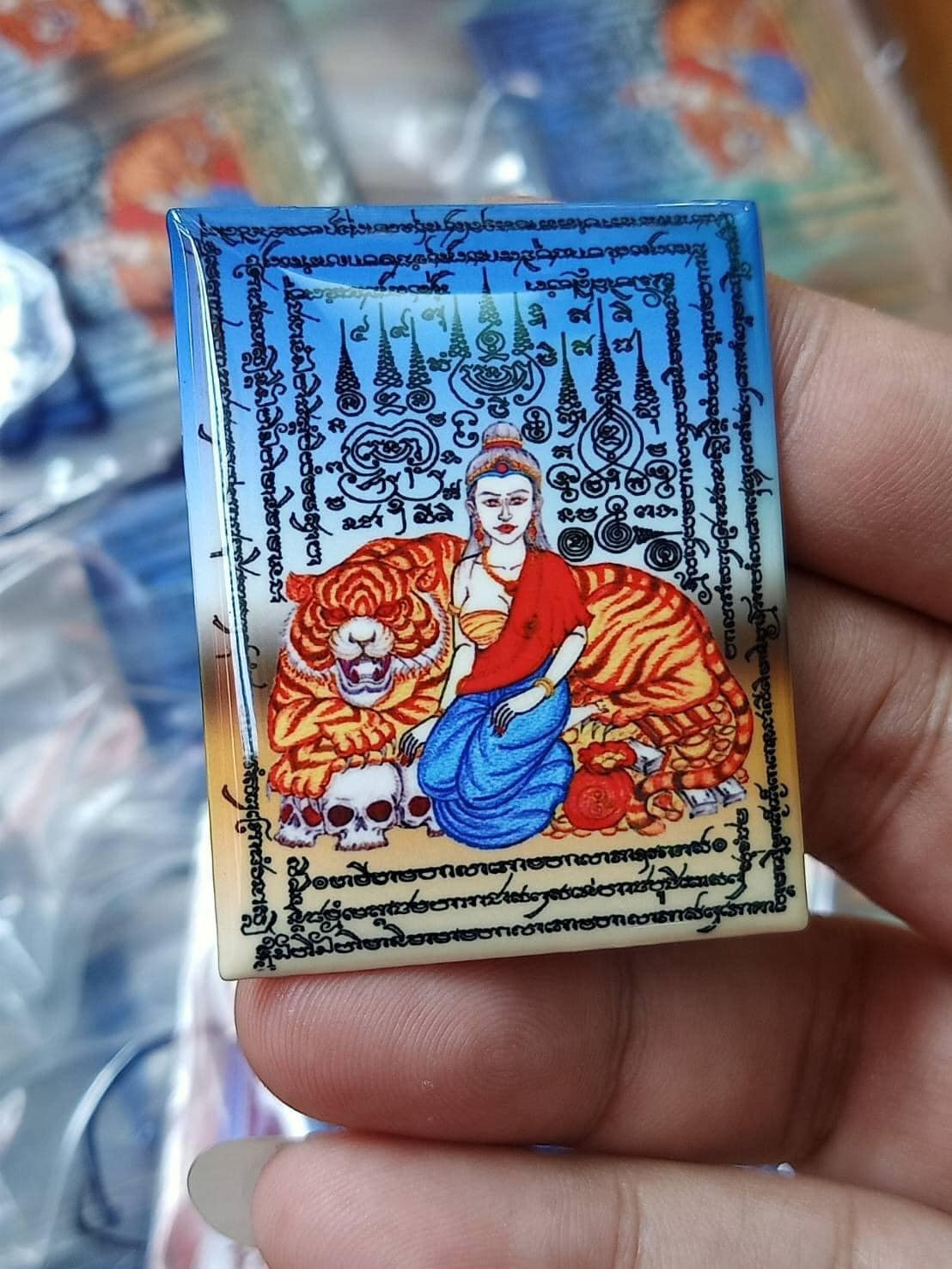 Phayak Naree tiger goddess amulet handheld rectangular laminated talisman card showing goddess seated on tiger with yantra script