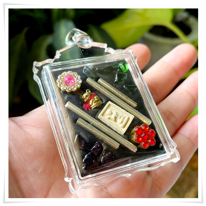 Phayak Naree tiger goddess amulet in clear plastic case with metal rods gold plaque red floral gem