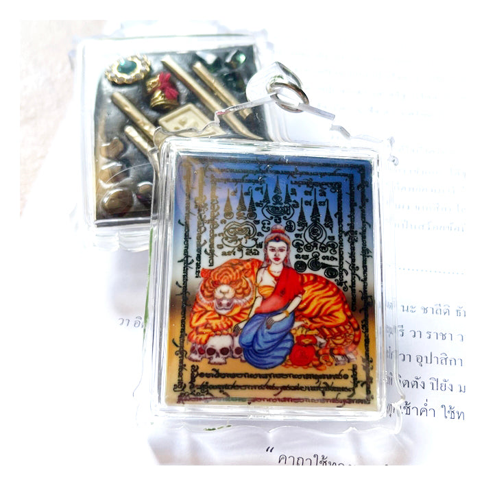 Phayak Naree tiger goddess amulet in clear plastic case showing seated goddess with tiger and Thai yantra script