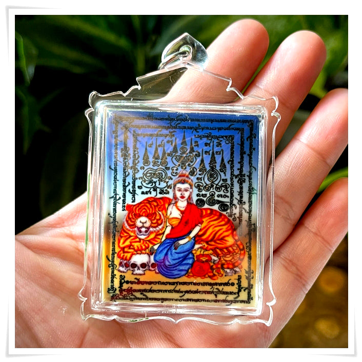 Phayak Naree tiger goddess amulet in clear plastic case showing seated goddess with tiger skulls and yantra script held in hand