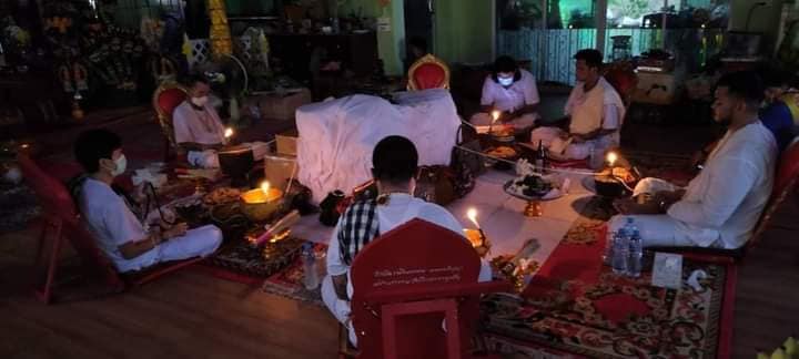 Group performing ritual blessing with candles and offerings for Phayak Naree tiger goddess amulet