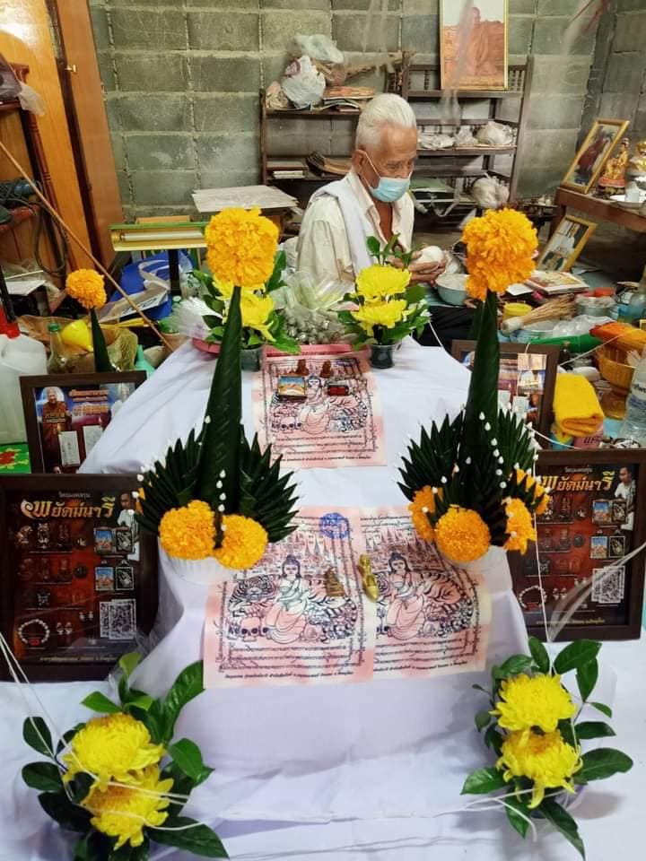 Phayak Naree tiger goddess amulet displayed on ceremonial altar with marigold flowers and banana leaf arrangements