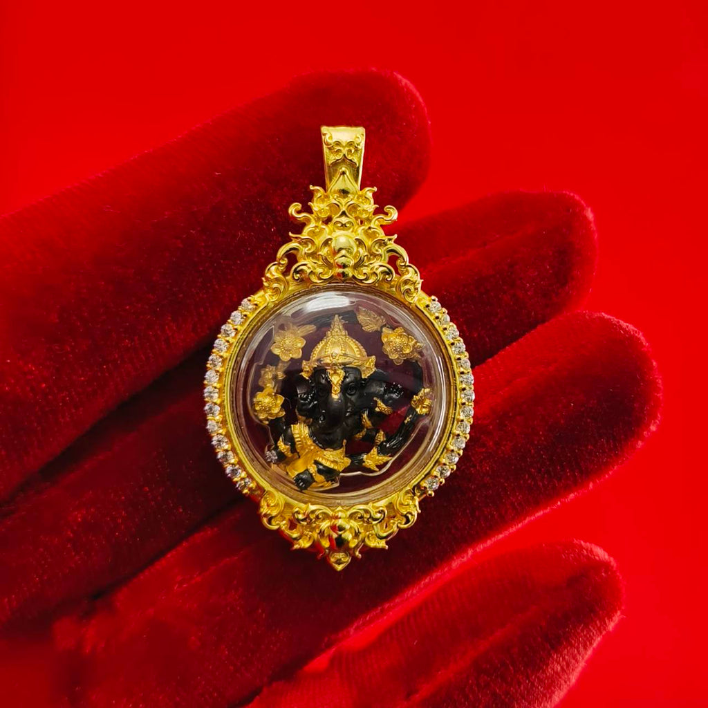Gold Phra Brahma amulet for protection with intricate detailing and clear casing displayed on a red background