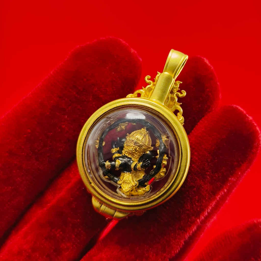 Phra Brahma amulet for protection in gold casing displayed on a red background