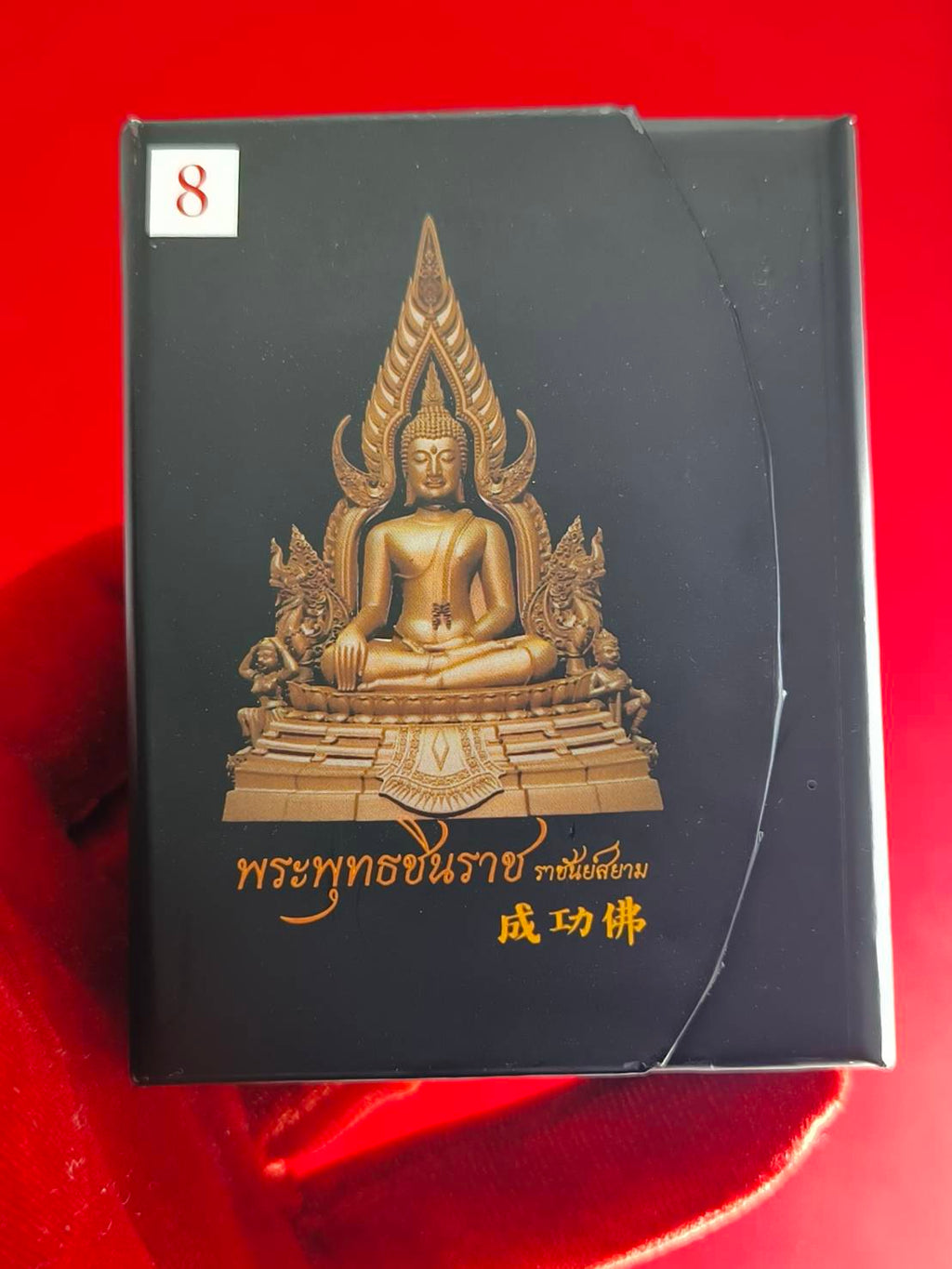 Phra Buddha Chinnarat amulet in a decorative box symbolizing faith and spirituality