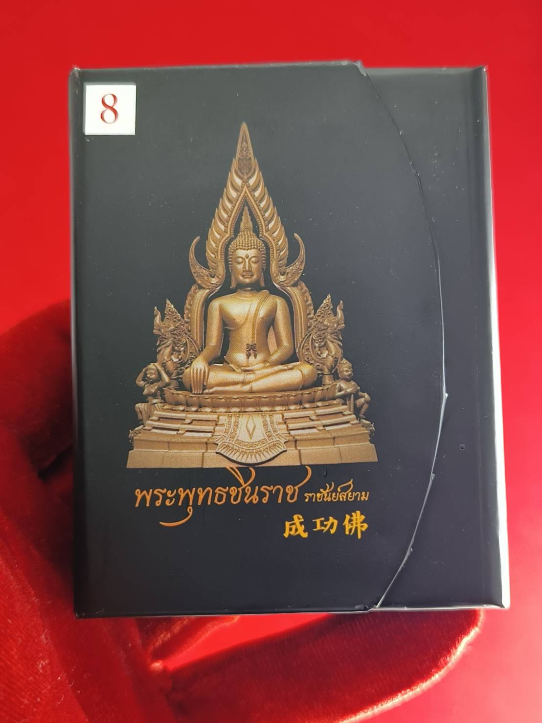 Phra Buddha Chinnarat amulet in a decorative box symbolizing faith and spirituality