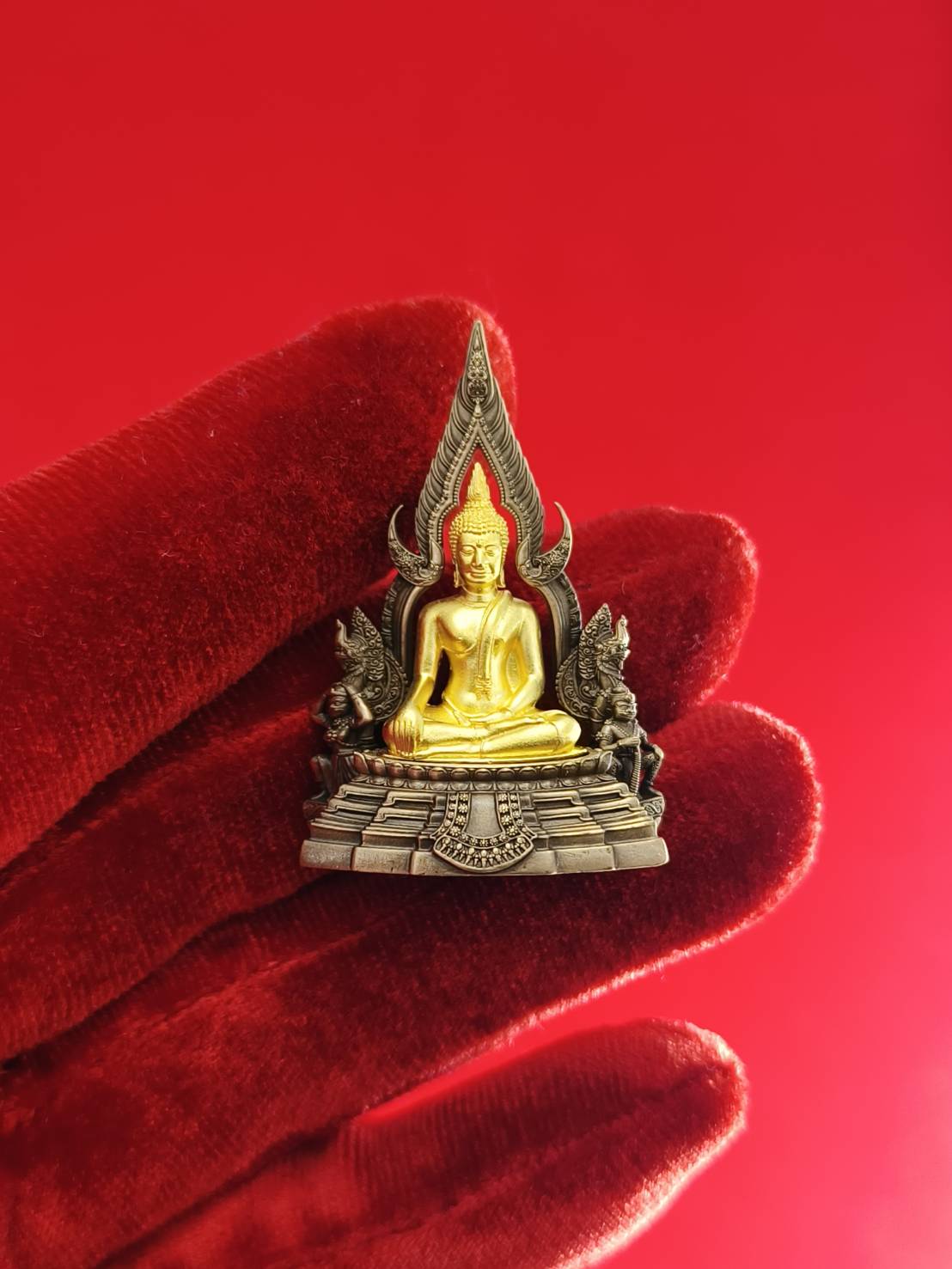 Phra Buddha Chinnarat amulet in gold color with intricate details and protective design for decorative purposes