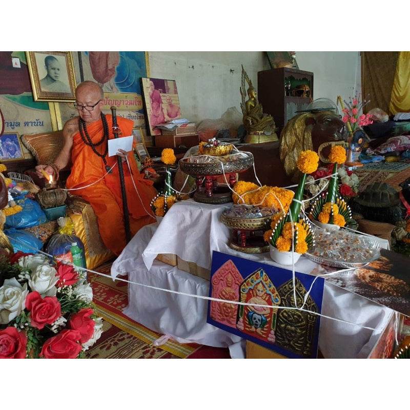 Phra Khun Paen Pacha-Da amulet for charm placed on an altar surrounded by offerings and decorations