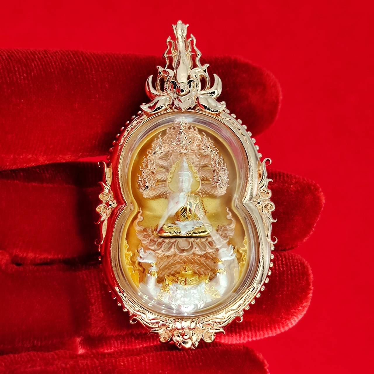 Phra Naga Prok amulet for protection with intricate gold detailing and a serene Buddha figure
