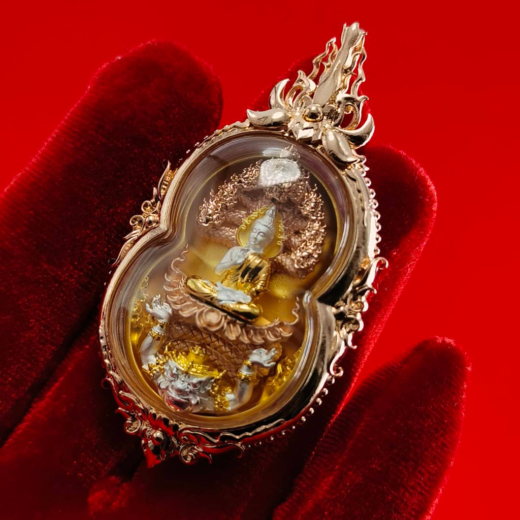 Phra Naga Prok amulet for protection in ornate gold casing held against a red background