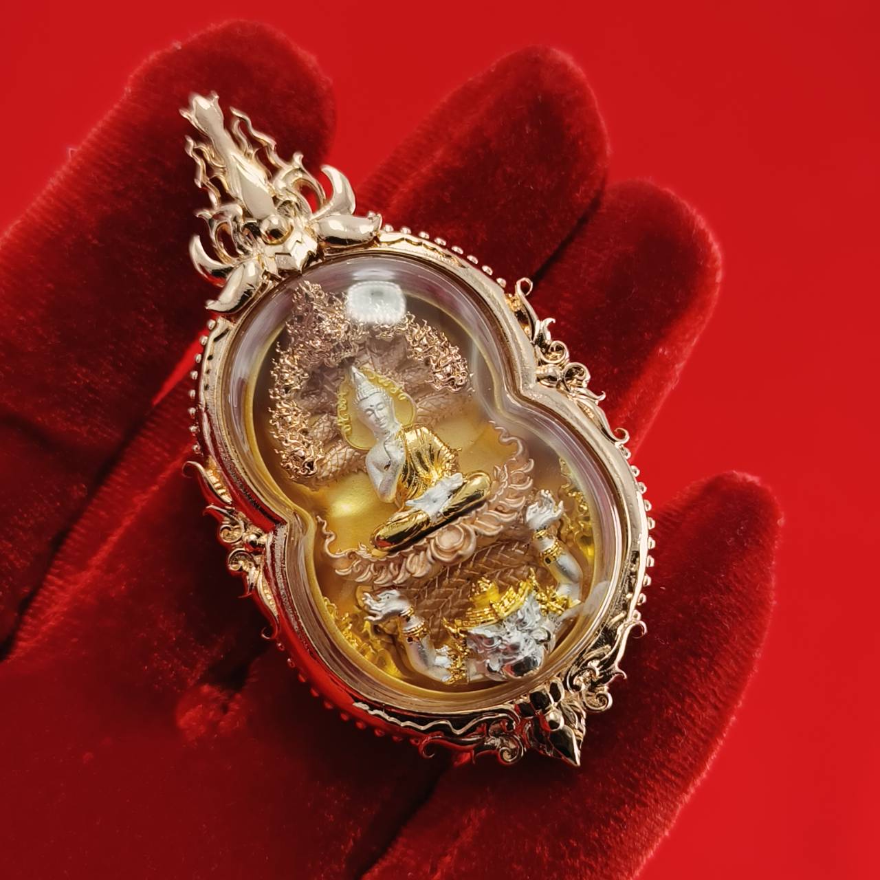Phra Naga Prok amulet for protection beautifully crafted in a gold frame depicting a serene Buddha figure.