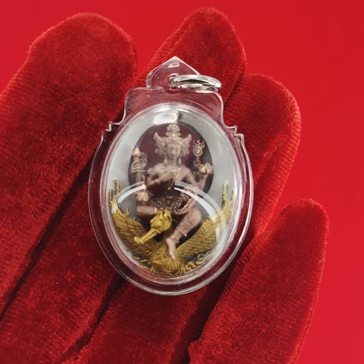 Phra Phrom Thai amulet encased in clear plastic with intricate details and vibrant colors for spiritual protection