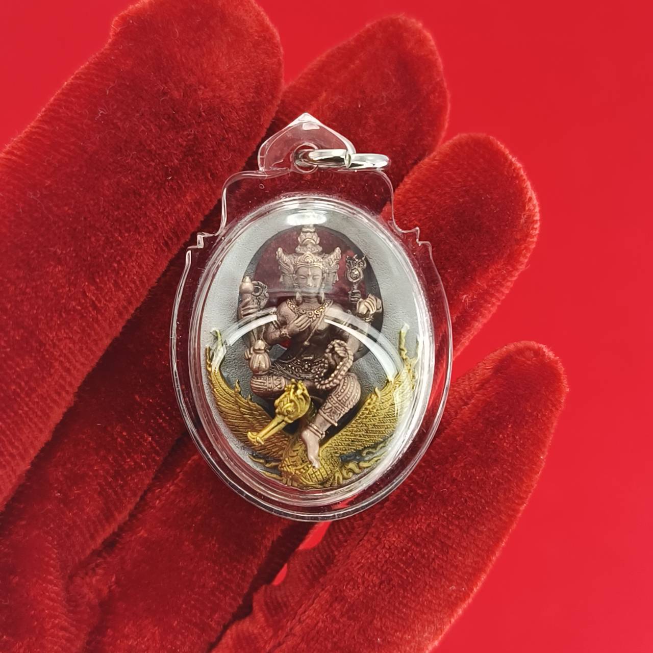 Phra Phrom Thai amulet encased in clear plastic, featuring intricate details and vivid colors