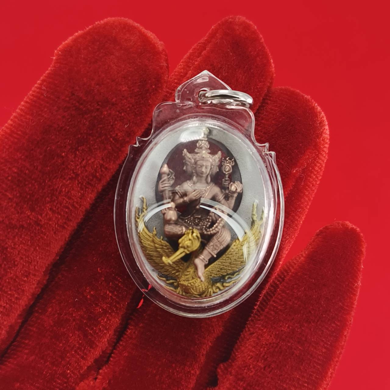 Phra Phrom Thai amulet with intricate design, held in a clear casing for protection and display