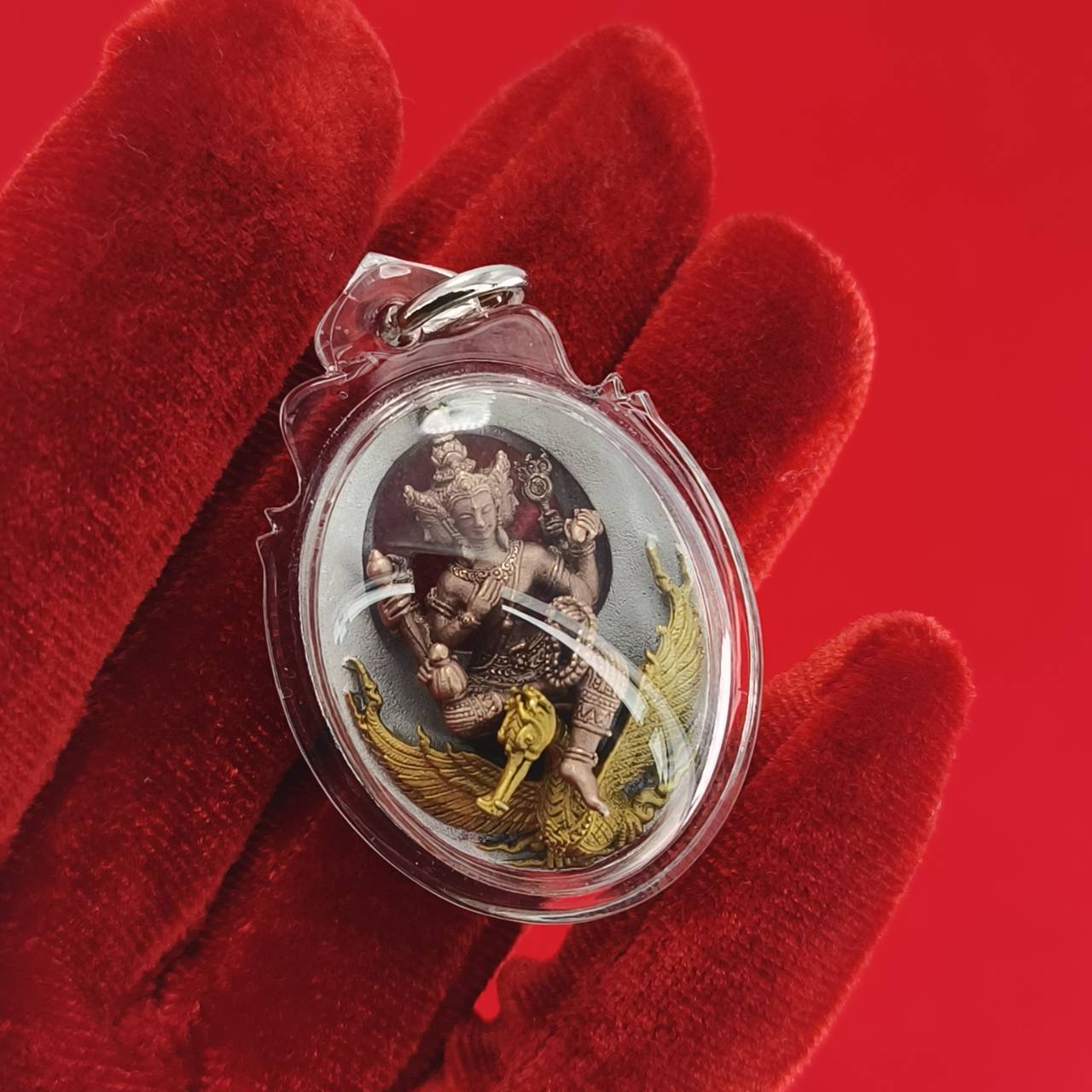 Phra Phrom Thai amulet featuring intricate details and vibrant colors, held in a protective casing