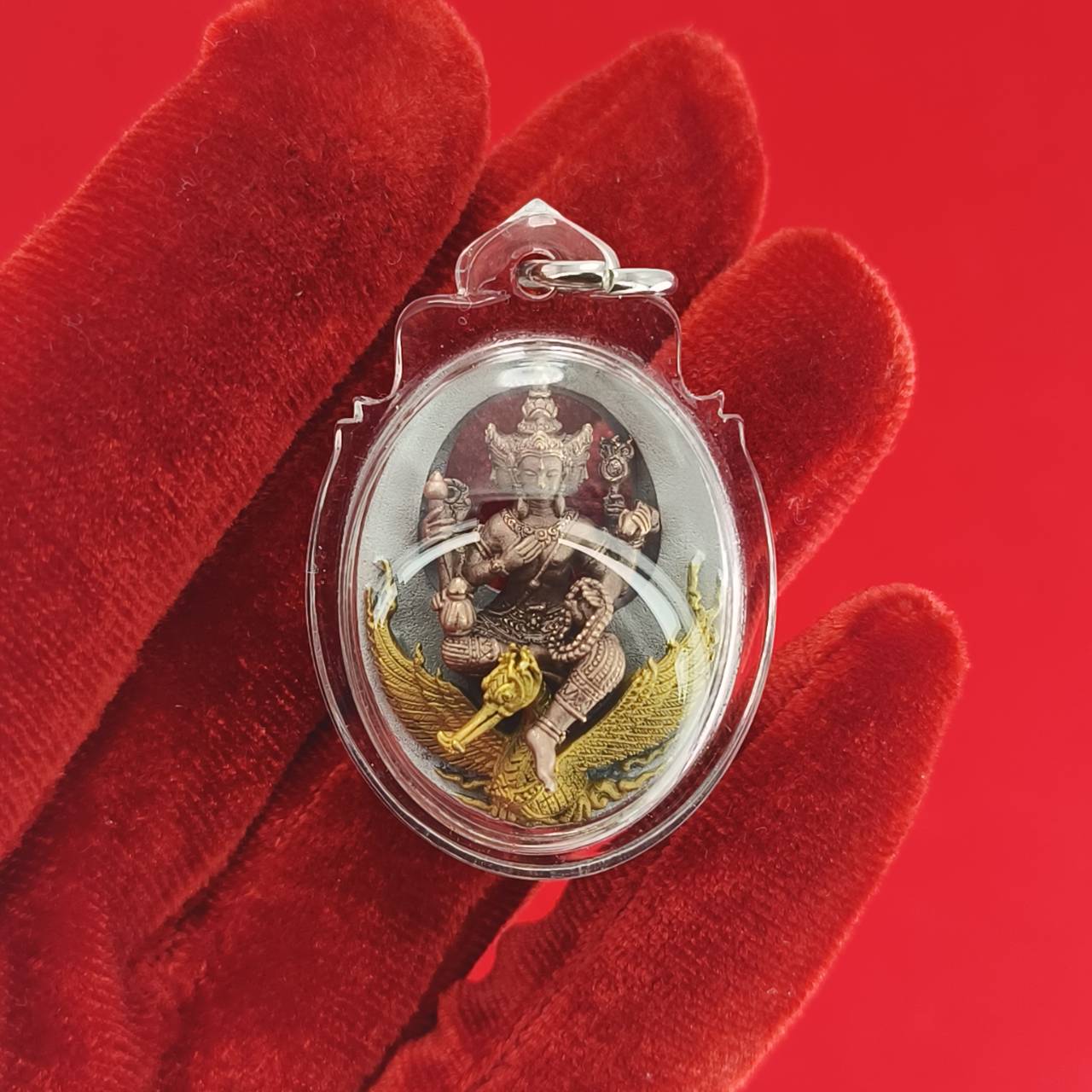 Phra Phrom Thai amulet enclosed in clear casing, featuring gold detailing and intricate design for spiritual protection