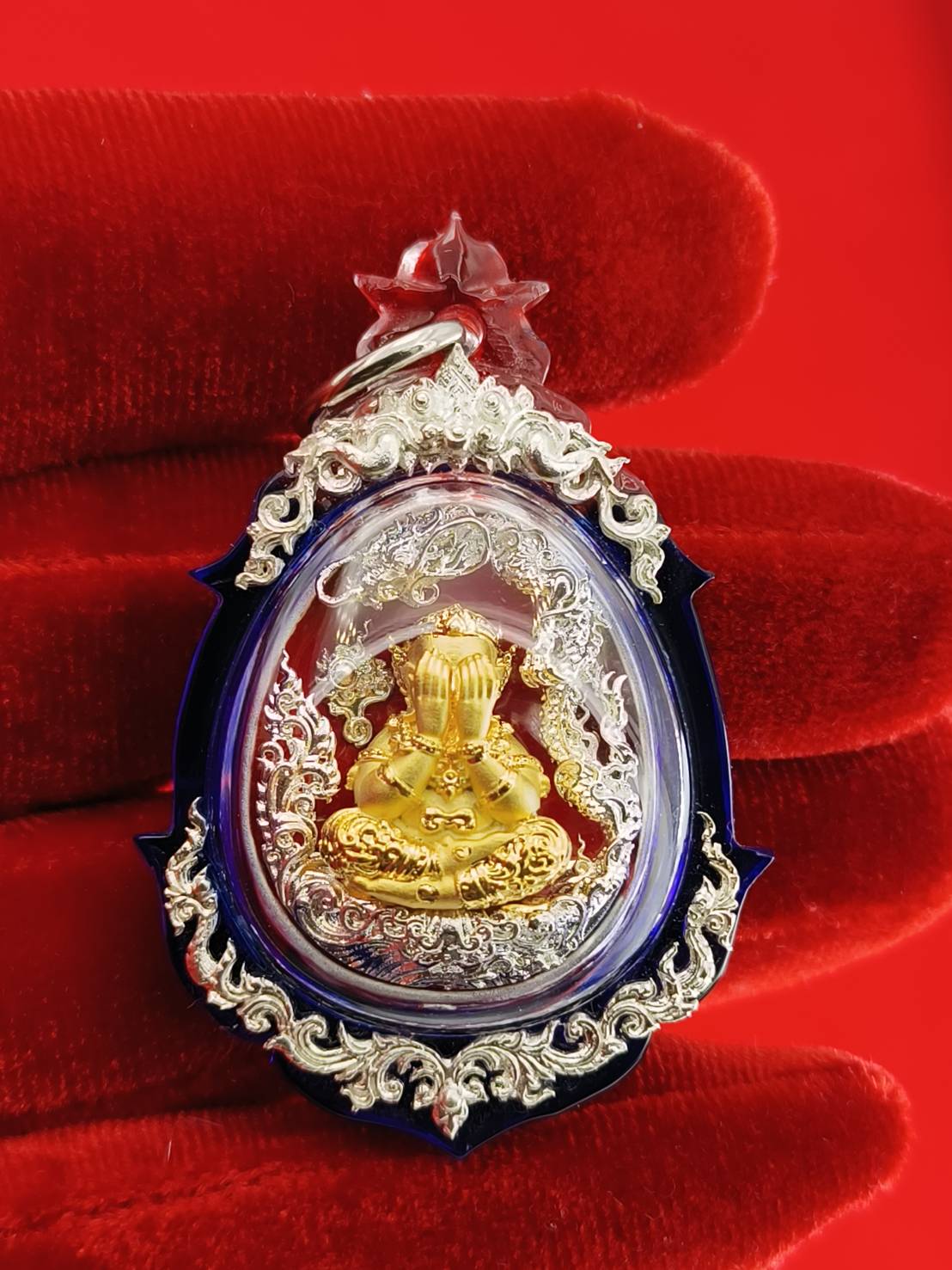 Phra Pidta amulet for wealth in a decorative case with intricate silver detailing
