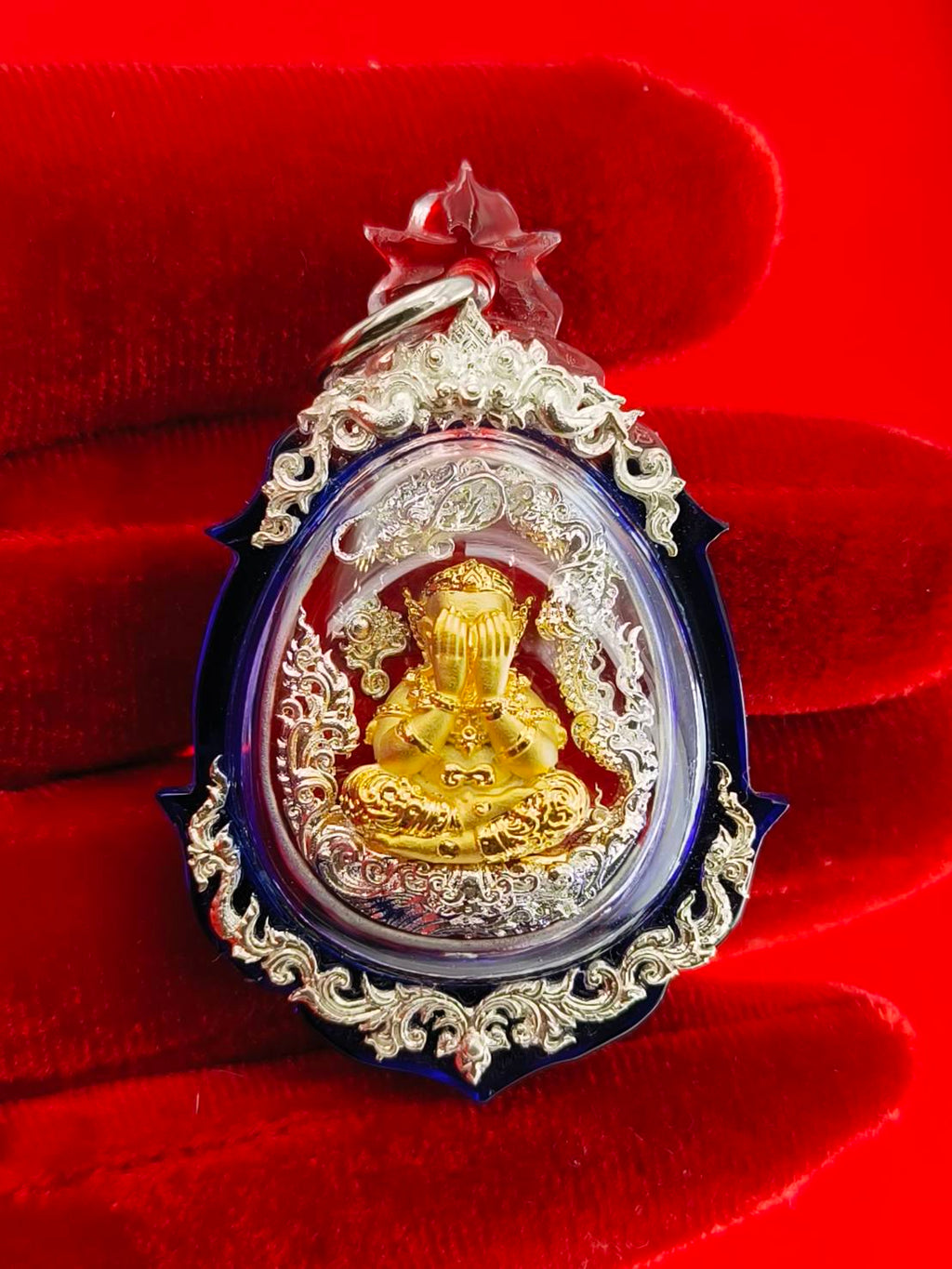 Phra Pidta amulet for wealth in ornate casing, featuring a gold Buddha figure and intricate details