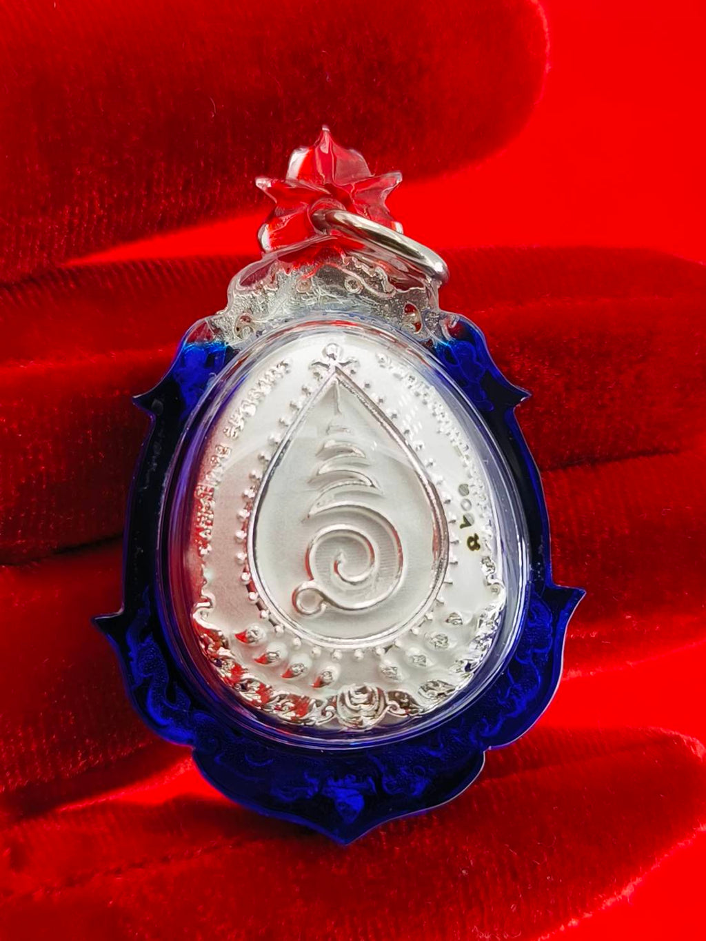 Phra Pidta amulet for wealth with detailed silver design and blue frame, perfect for collectors and home decor