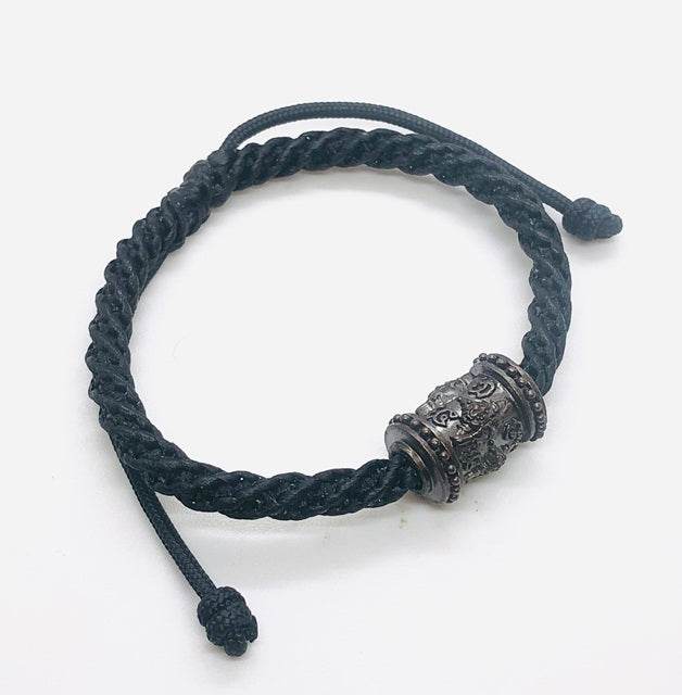 Phra Rahu amulet for luck on a braided black cord bracelet, designed for style and spiritual protection