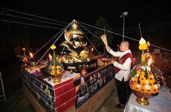 Ceremonial display featuring a Phra Rahu amulet for luck surrounded by traditional offerings and decorations