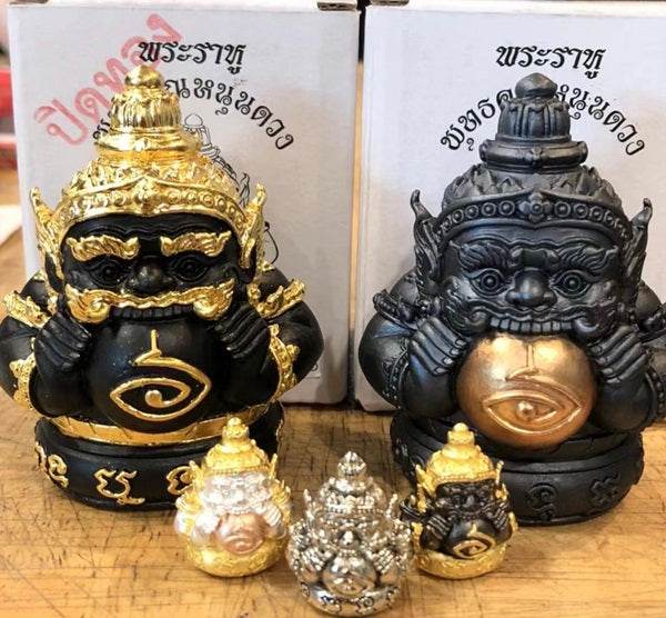 Phra Rahu amulet for luck displayed with gold and black figurines, ideal for decoration and spiritual energy