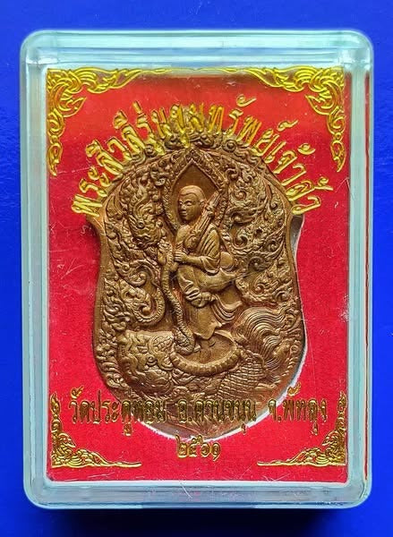 Phra Siwali amulet for wealth in ornate gold casing with Thai script on red background