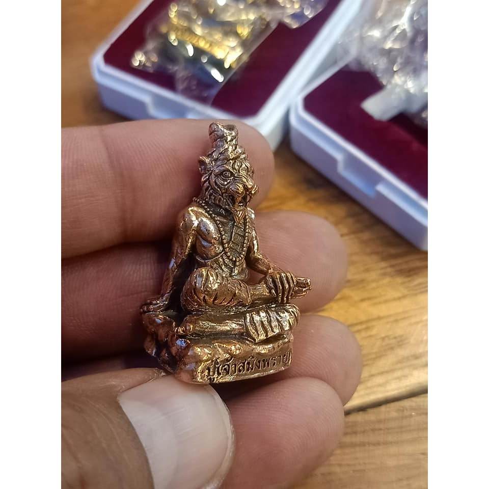 Phu Chao Saming Phrai spirit figurine in hand, symbolizing Thai feng shui and spirituality