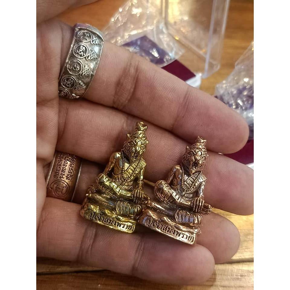 Phu Chao Saming Phrai spirit figurine in gold and bronze finishes, held in a hand for size reference